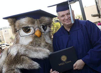 Sage the Owl mascot posing with a WGU graduate