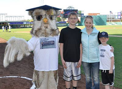 Sage the Owl mascot posing with a family at a baseball game