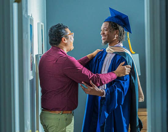 Mentor congratulating a student who is getting ready for graduation ceremony
