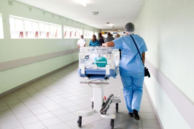 Nurse pushing hospital equipment