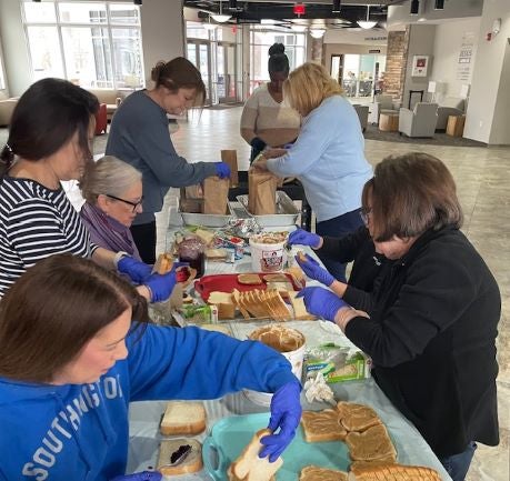 Feed the Need Northeast volunteers making brown bag lunches to go