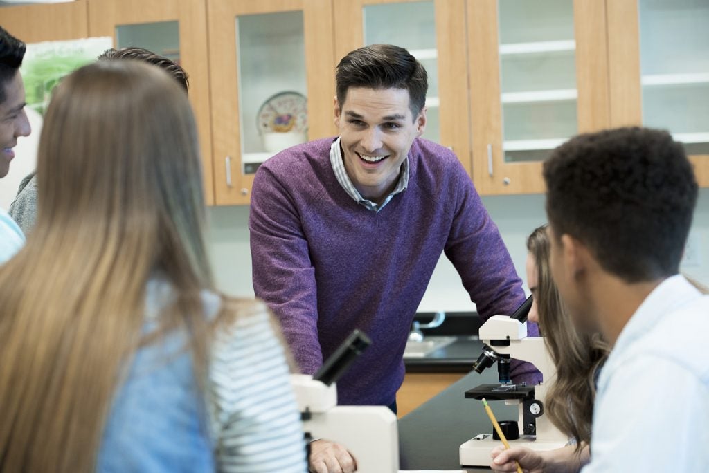 Smiling teacher in a classroom with students