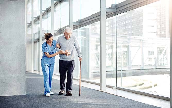 Shot of a female nurse assisting her senior patient while walking