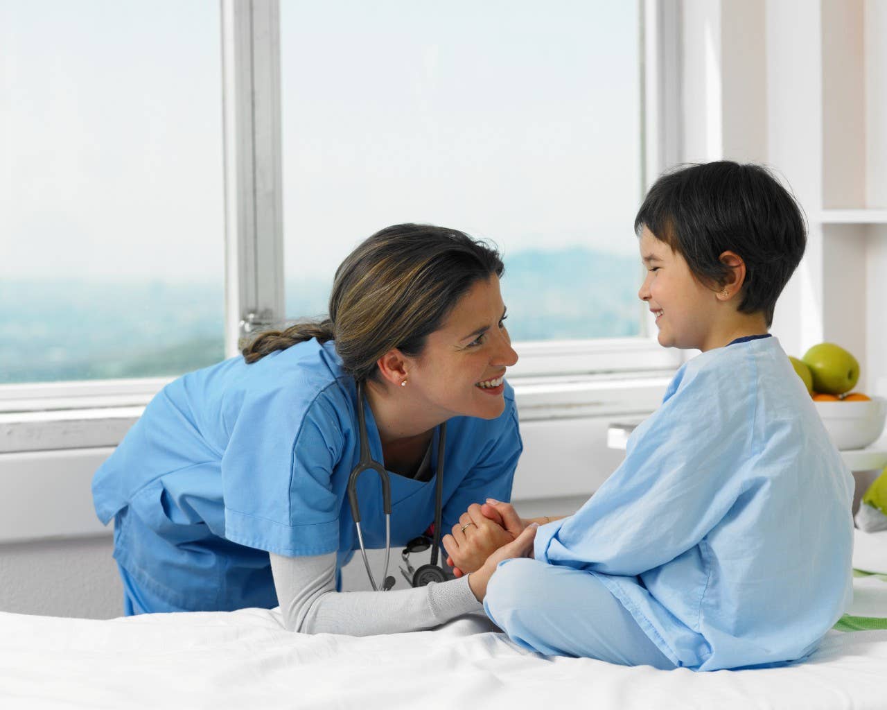 nurse smiling at a child in the hospital 