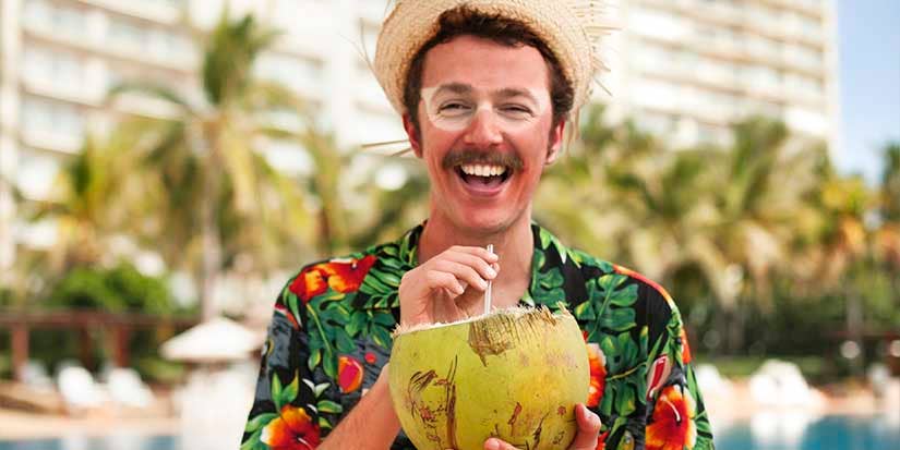 Happy Man Drinking from Coconut