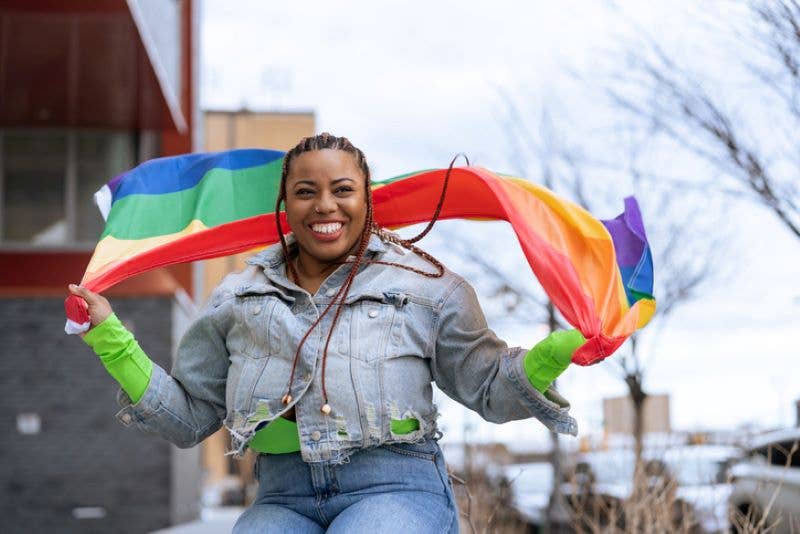 An LGBTQ advocate holds a rainbow flag