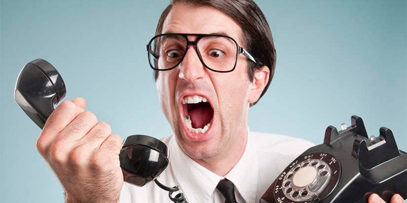 Man with glasses yelling into a phone.