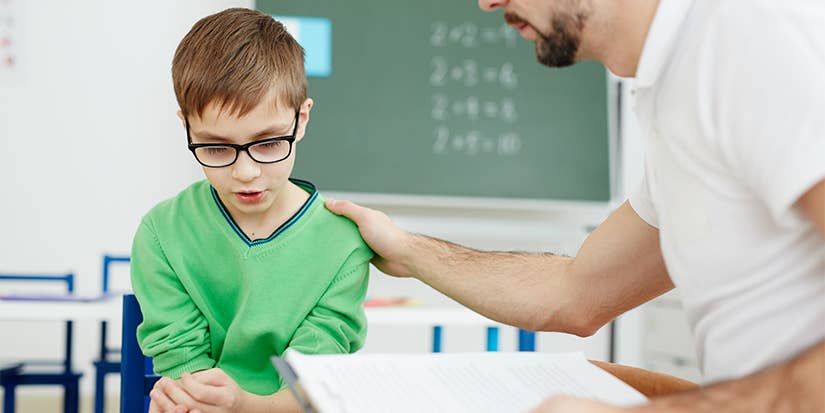 Teacher supporting upset or confused schoolboy during individual lesson