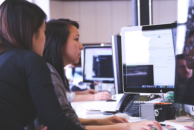 Computer programmers looking over code