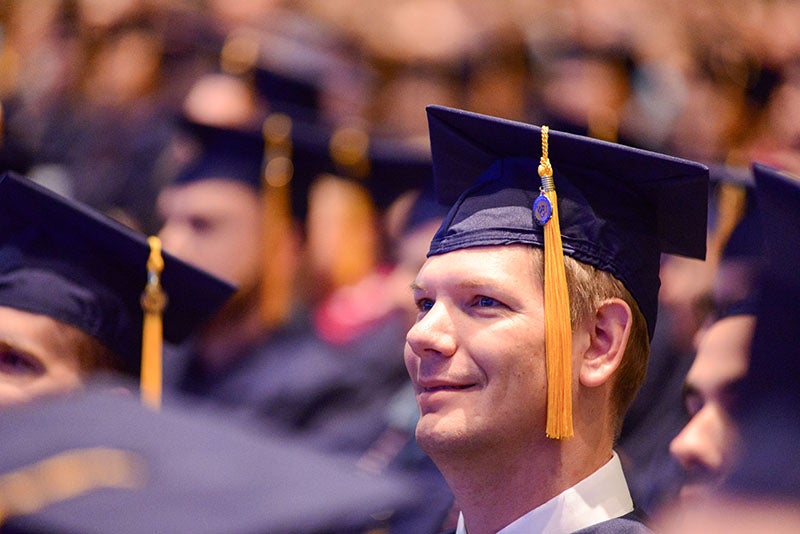 male graduate looking on