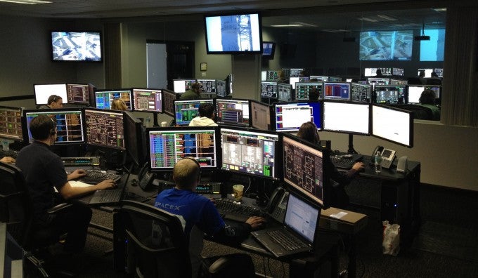 Group of people working on cyber security computers.