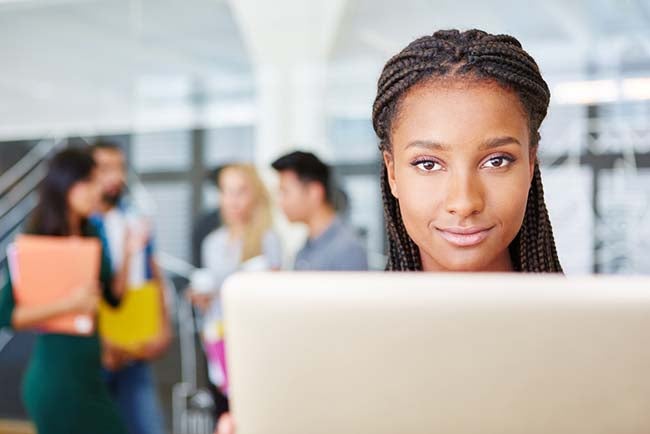 Woman happily sitting at a computer.