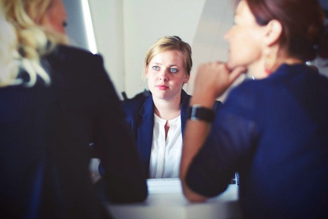 Three women meeting, one looking bored