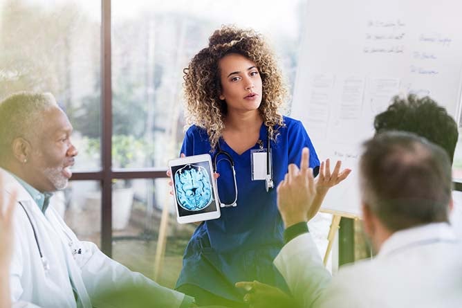 A young doctor holds a tablet displaying