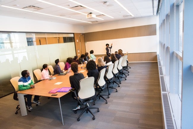 Boardroom full of people at table being trained by HR manager