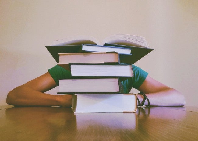 Student behind book stack