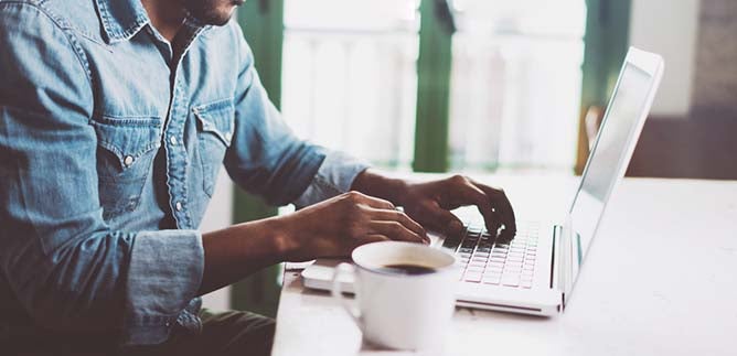 Man working at home using laptop near the big window. Remote work, online  job, work from home. Stock Photo