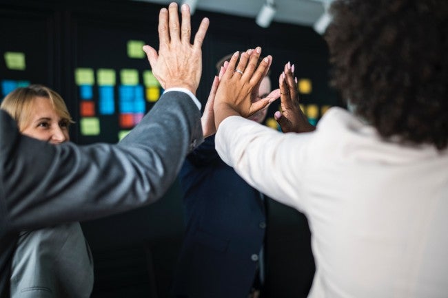 Office workers high fiving | team building activities