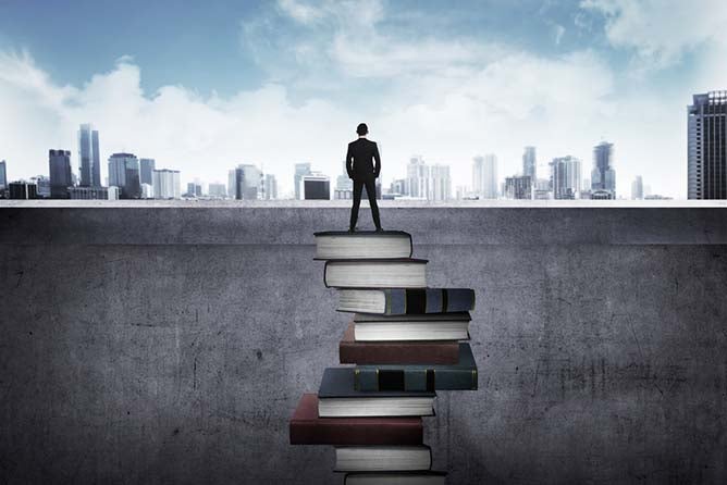 A tower of books allows a businessman to see the urban utopia of opportunity ahead.