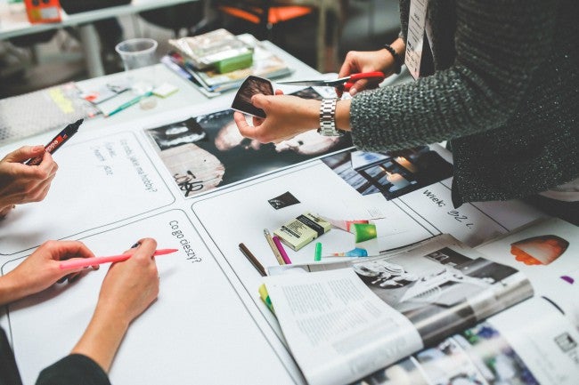 Hands working on traditional marketing