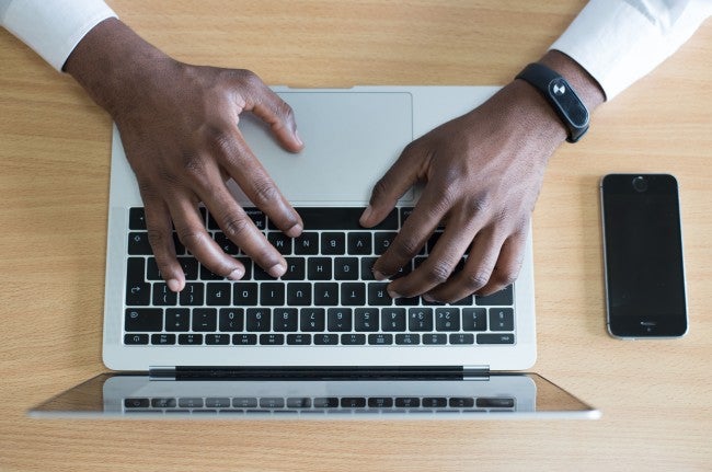 Man's hands typing on keyboard