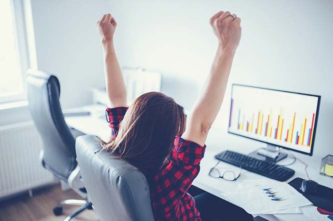 Portrait of happy young successful businesswoman celebrate something with arms up.