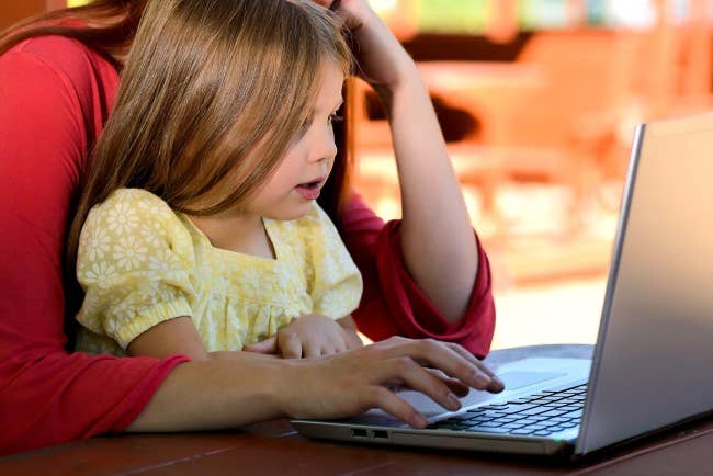Child and parent playing on computer