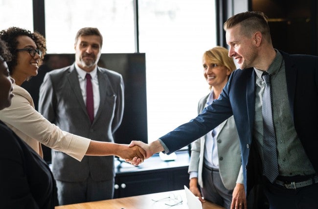 Woman and man shaking hand in room over business ethics