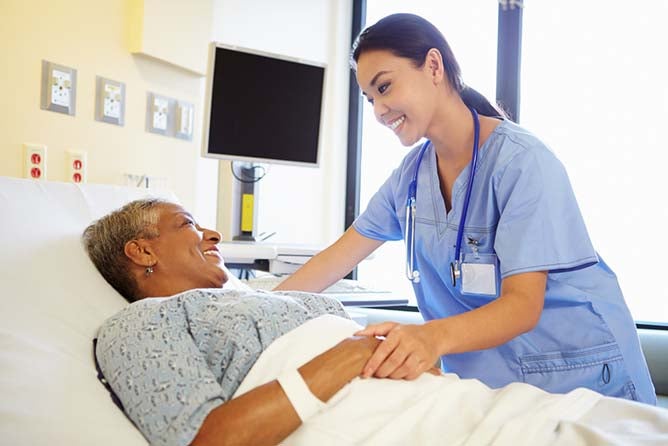 registered nurse helping a patient on a hospital bed