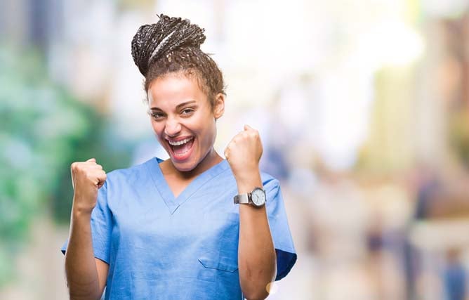 An excited nurse fist pumps due to her excitement.