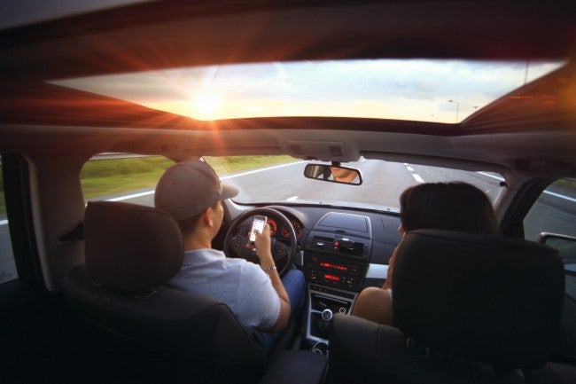 Man texting inside self driving car