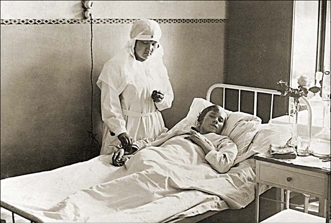 Vintage photo of a nurse tending to a sick patient.