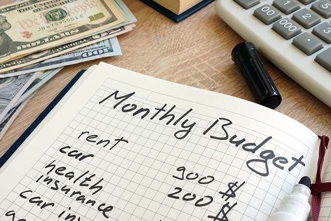 An open notebook with a monthly budget written inside.