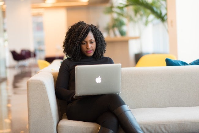 Woman sitting on sofa working at home