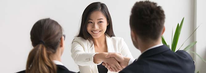 A young girls shakes hands with a couple interviewers after a successful meeting.
