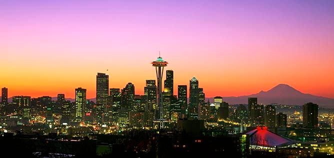 A sunset image of the Seattle skyline with Mount Rainier sitting in the background.