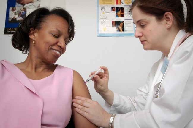 Nurse administering vaccine to woman