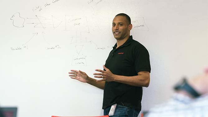 WGU grad, Andre Alfred, presents before a group of his peers.
