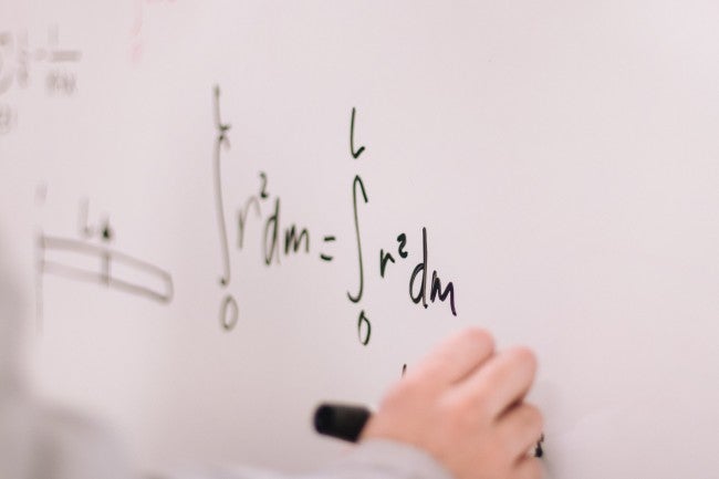 Math teacher writing equation on the board