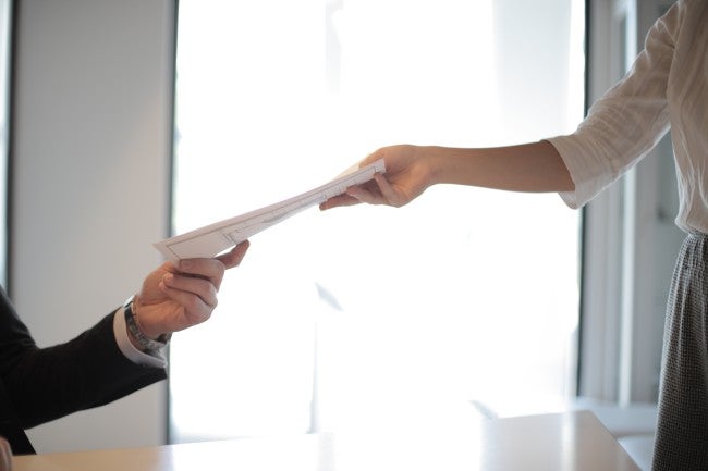 Woman handing man a resume