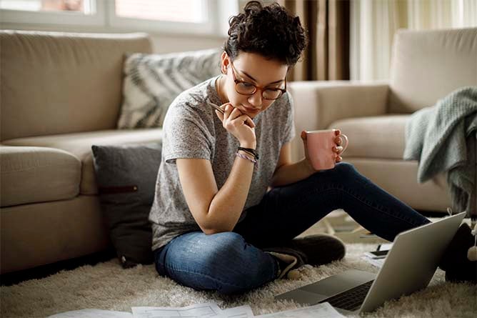 A young girl studies in the comfort of her own home.