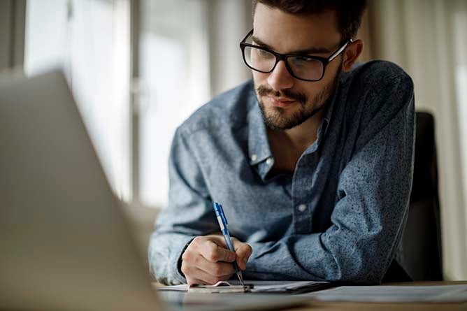 A young man works on a laptop.