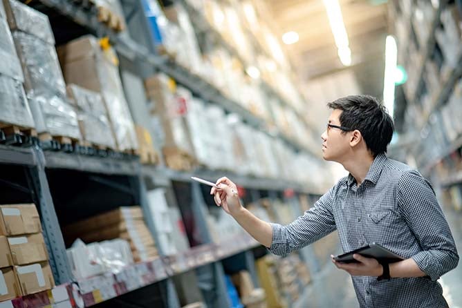 A young product manager take inventory in a warehouse.