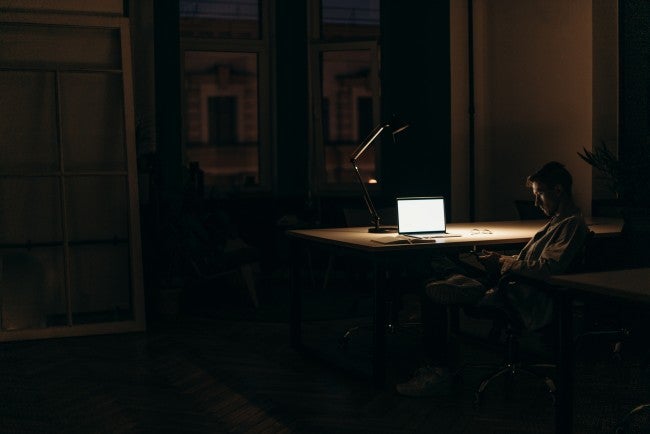 Man sitting at computer with lamp late at night