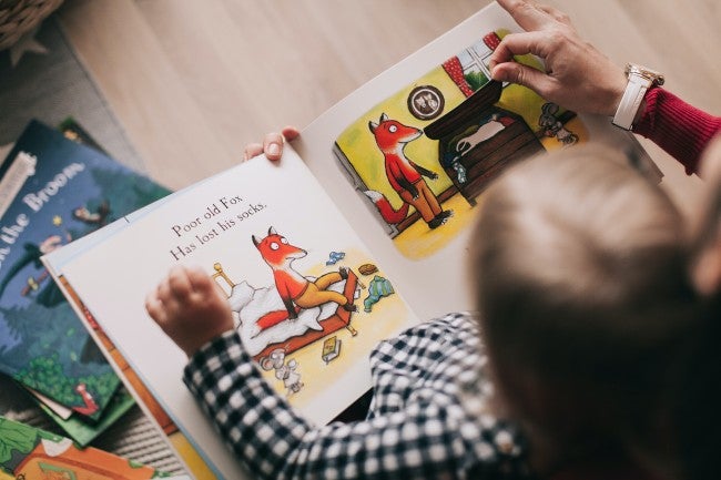 Teacher reading book to young child