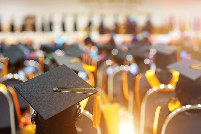 Photo taken behind a graduate during a graduation ceremony.