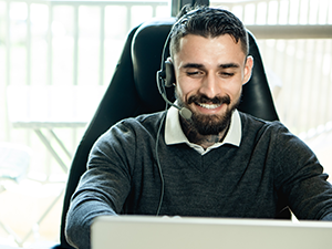man in headset looking at computer