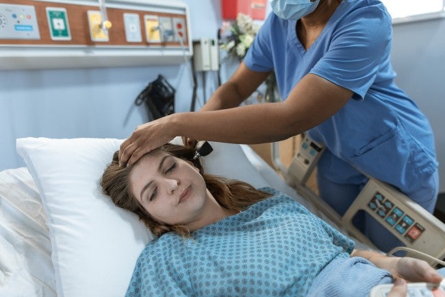 ICU nurse taking patient temperature