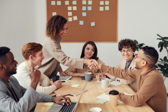 Charismatic leader shaking hands in board room