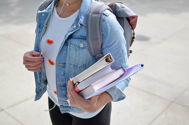 person holding a stack of books
